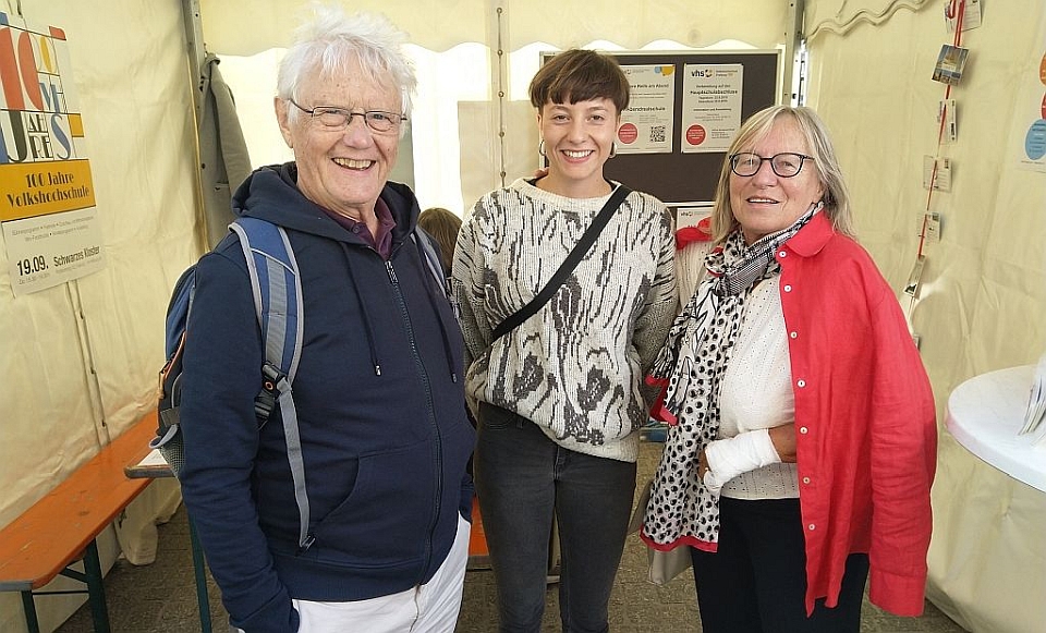 Foto: VHS 100 Jahr-Feier:  Besucherinnen und Besucher am Stand des Abendgymnasiums